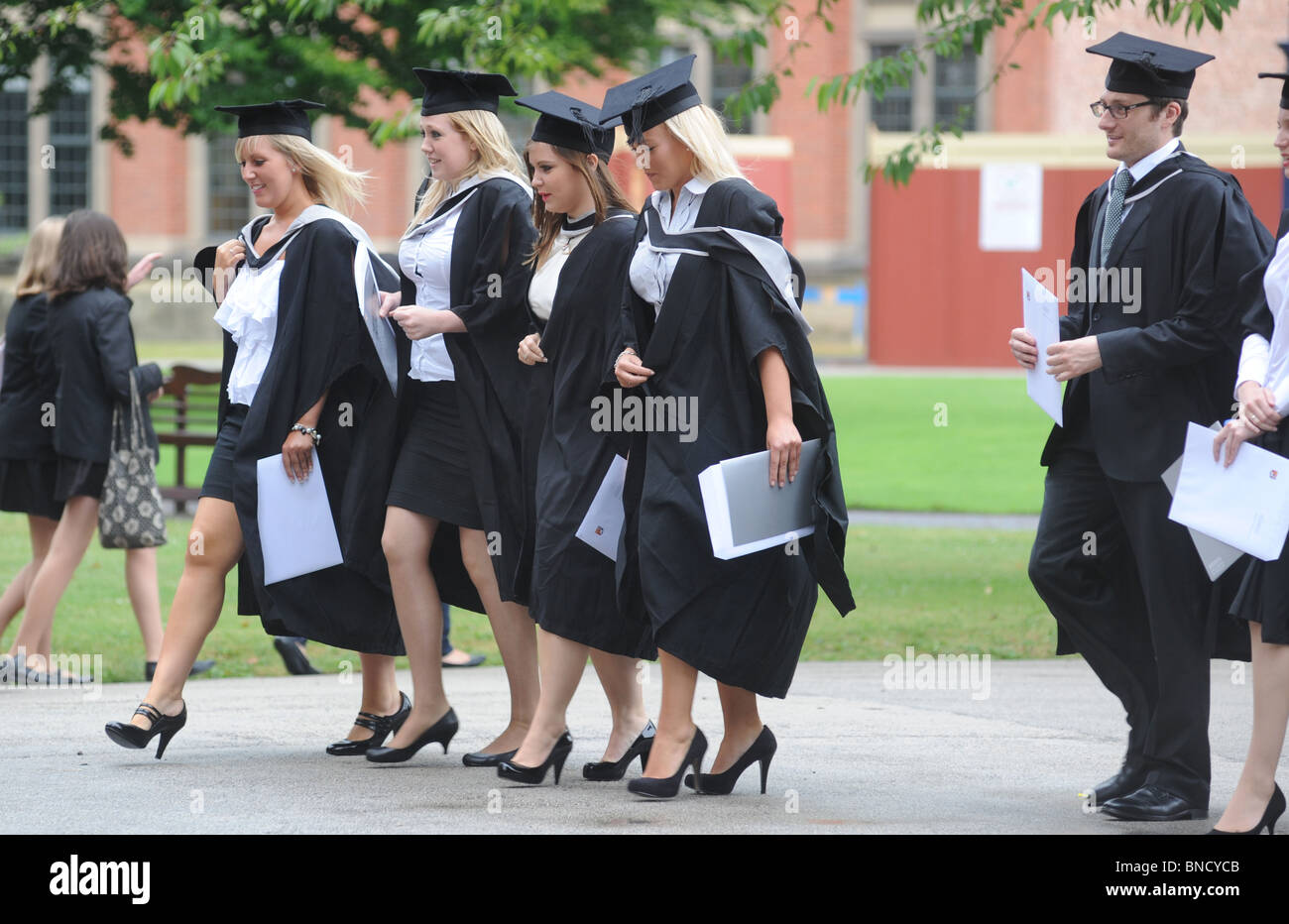 CELEBRATING GRADUATES FROM A BRITISH UNIVERSITY LEAVE THEIR GRADUATION CEREMONY WITH THEIR DEGREE CERTIFICATES,UK Stock Photo