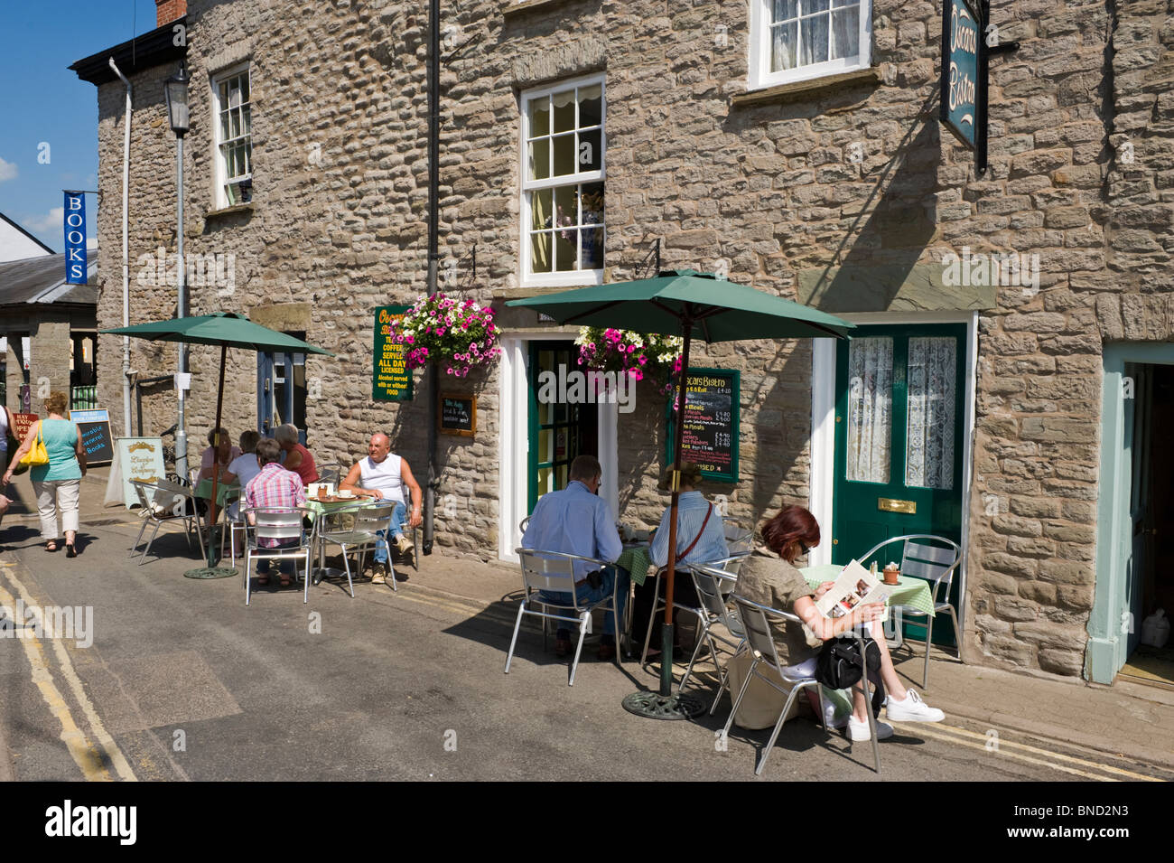 People eating and drinking outside café in Hay-on-Wye Powys Wales UK Stock Photo