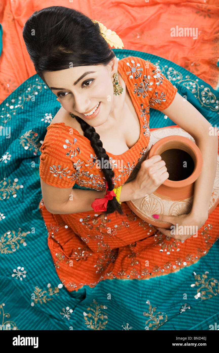 woman in lehenga choli holding a clay water pot BND4EJ