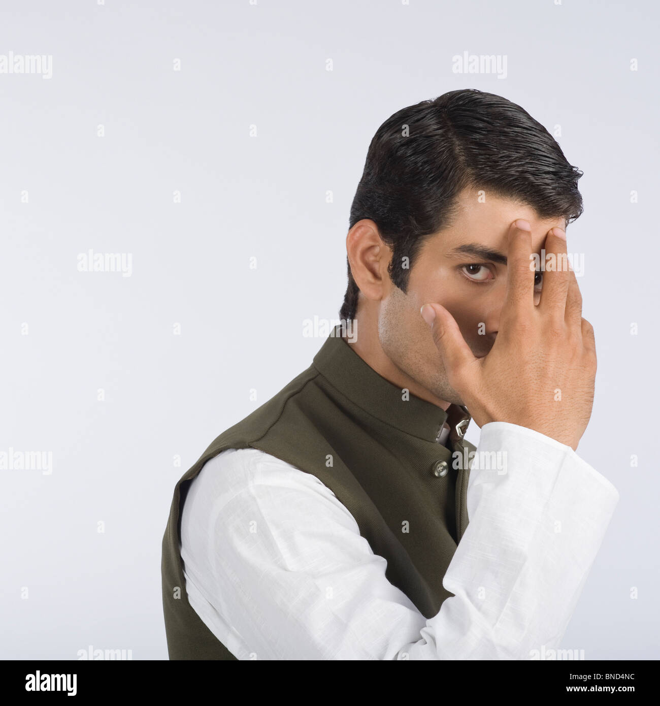 Close-up of an actor portraying a politician hiding his face Stock Photo