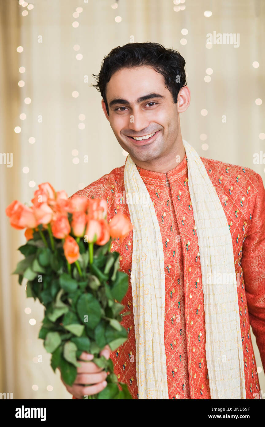Man holding a bouquet of roses and smiling Stock Photo - Alamy