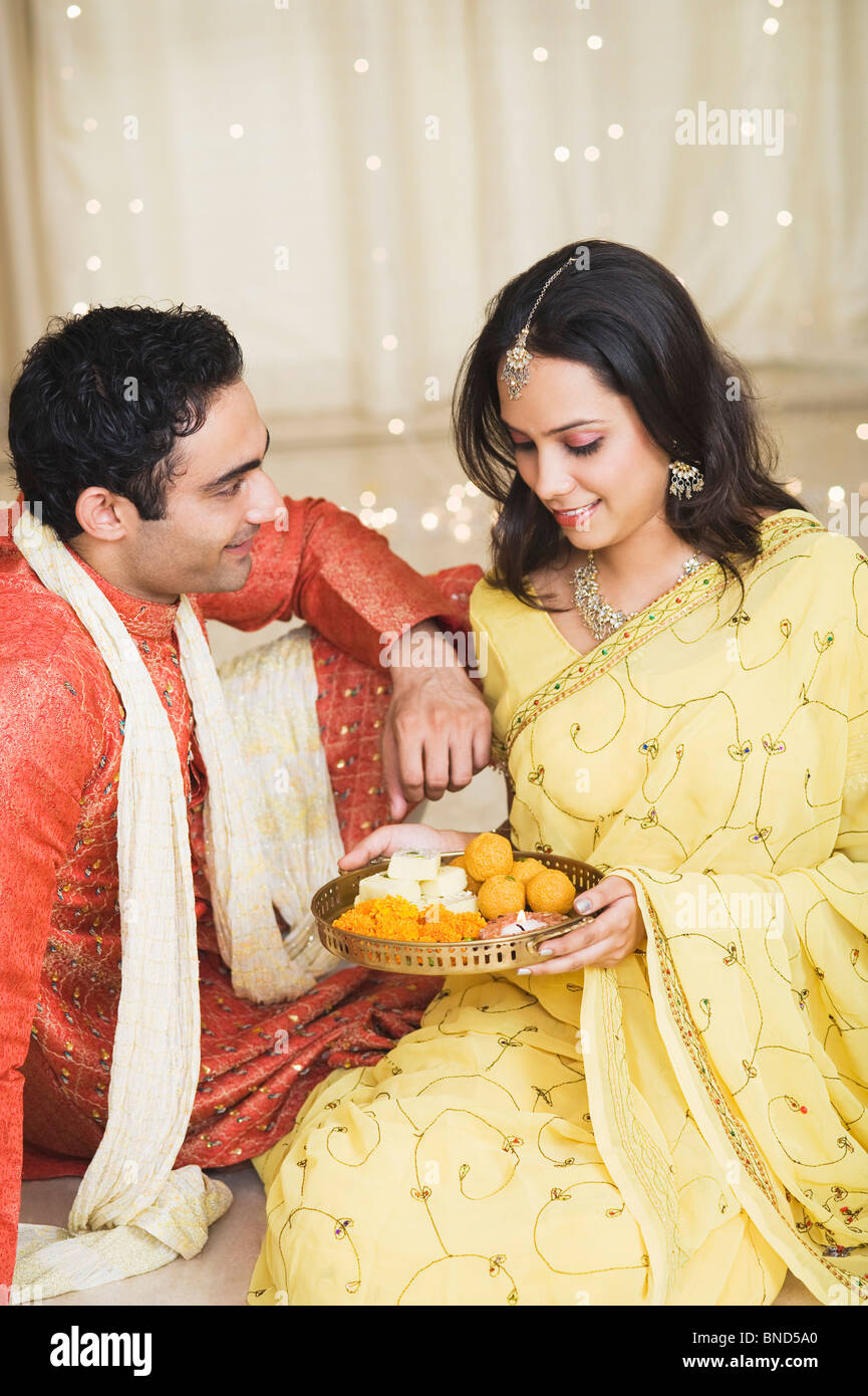 Couple sitting with a pooja thali of Diwali and smiling Stock Photo Alamy
