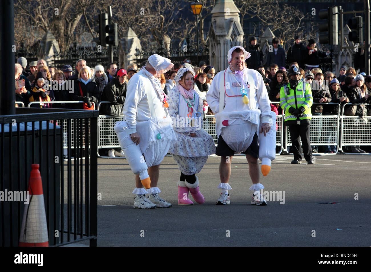 Three people dressed as babies in the New Years Day Parade, Westminster, London, SW1. Stock Photo