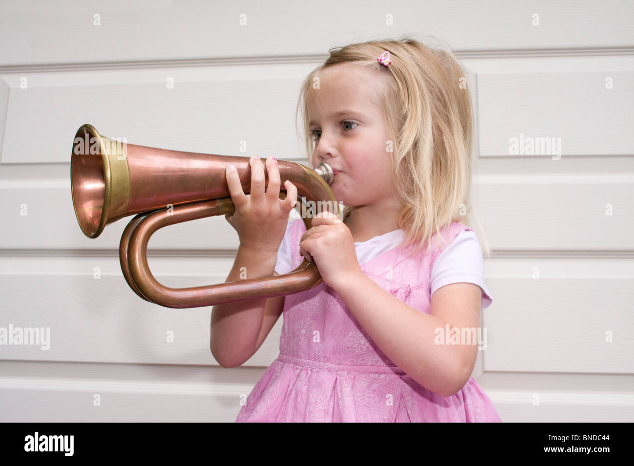 Young girl blowing a bugle Stock Photo Alamy