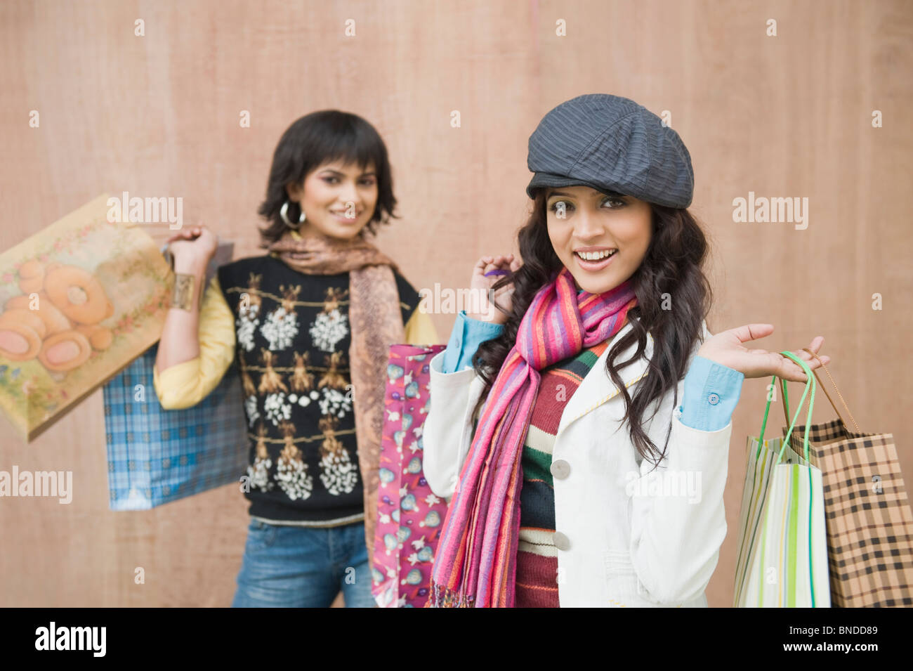 Portrait of two women holding shopping bags and smiling Stock Photo - Alamy