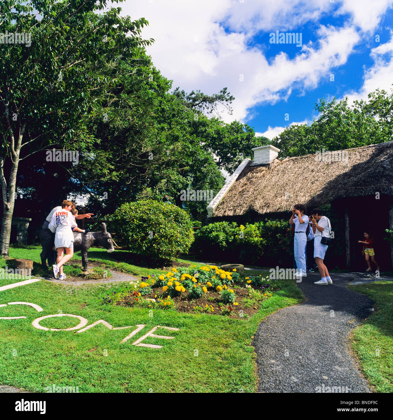 Tourists taking pictures, thatched cottage, 'Maam Cross', Connemara, County Galway, Republic of Ireland Stock Photo