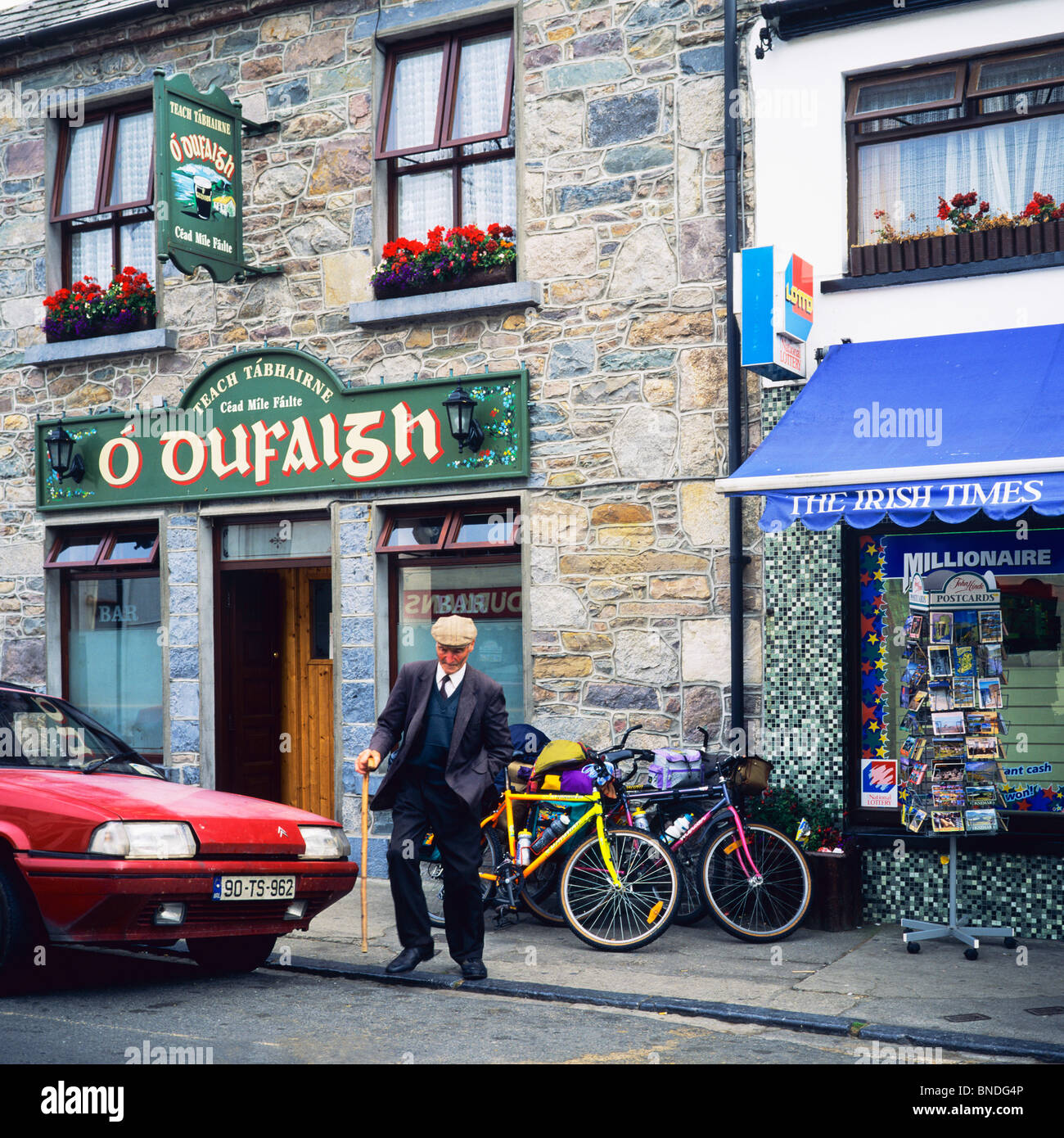 Elderly man with stick walking out from 'O'Oufaigh' bar, Louisburgh, County Mayo, Republic of Ireland, Europe, Stock Photo