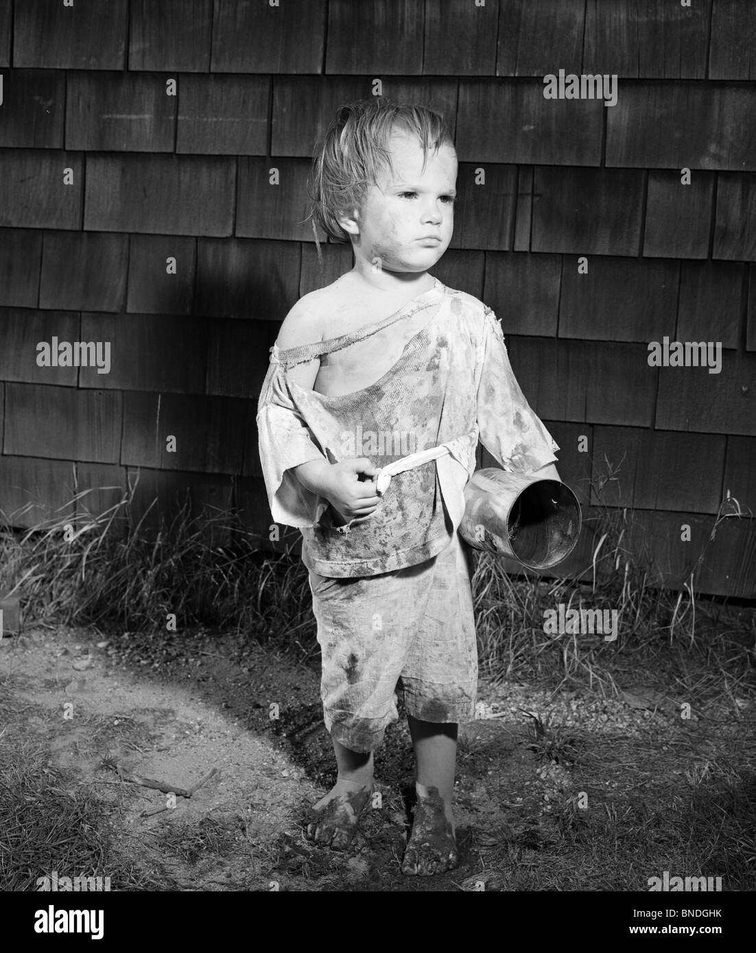 Filthy boy holding a can Stock Photo