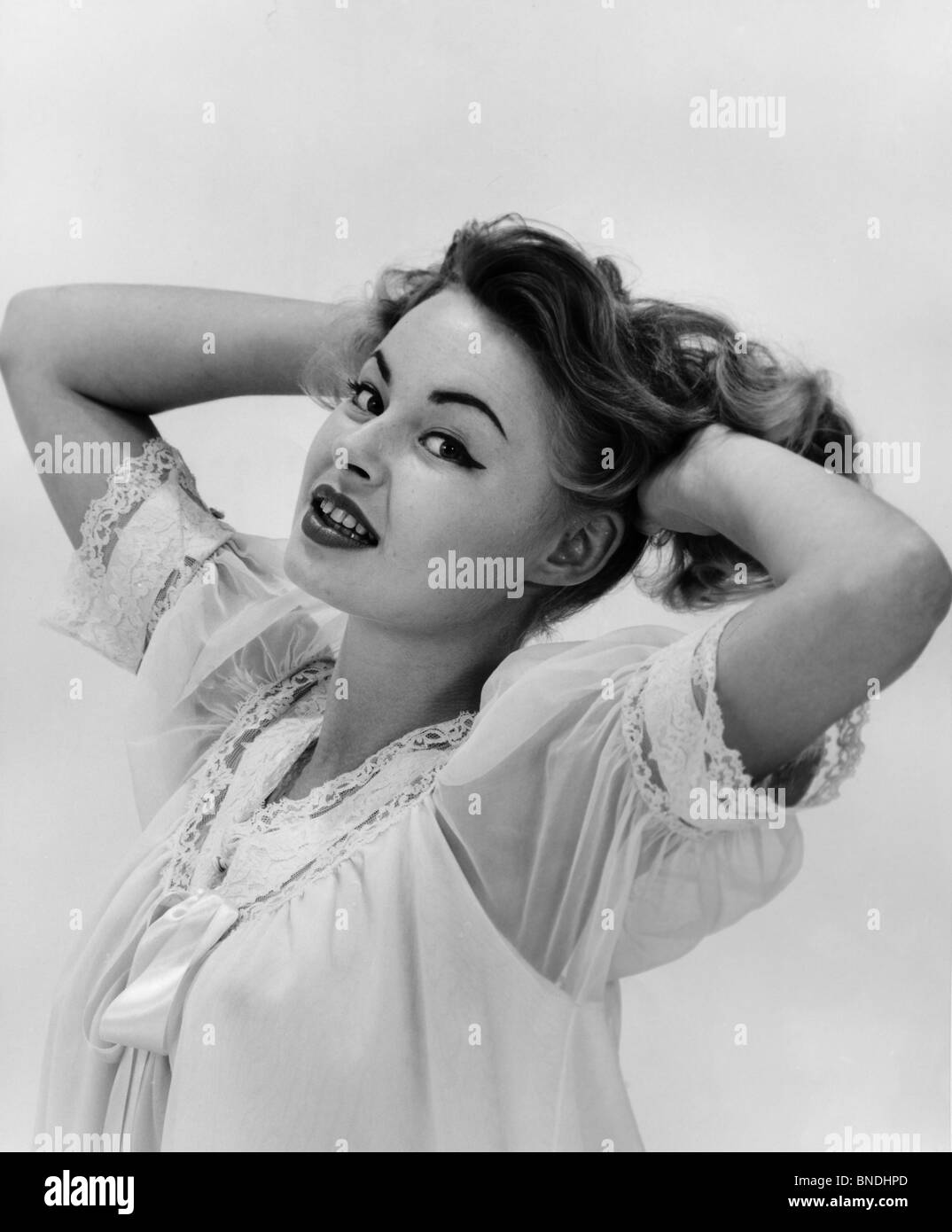 Portrait of a young woman with her hands in her hair Stock Photo