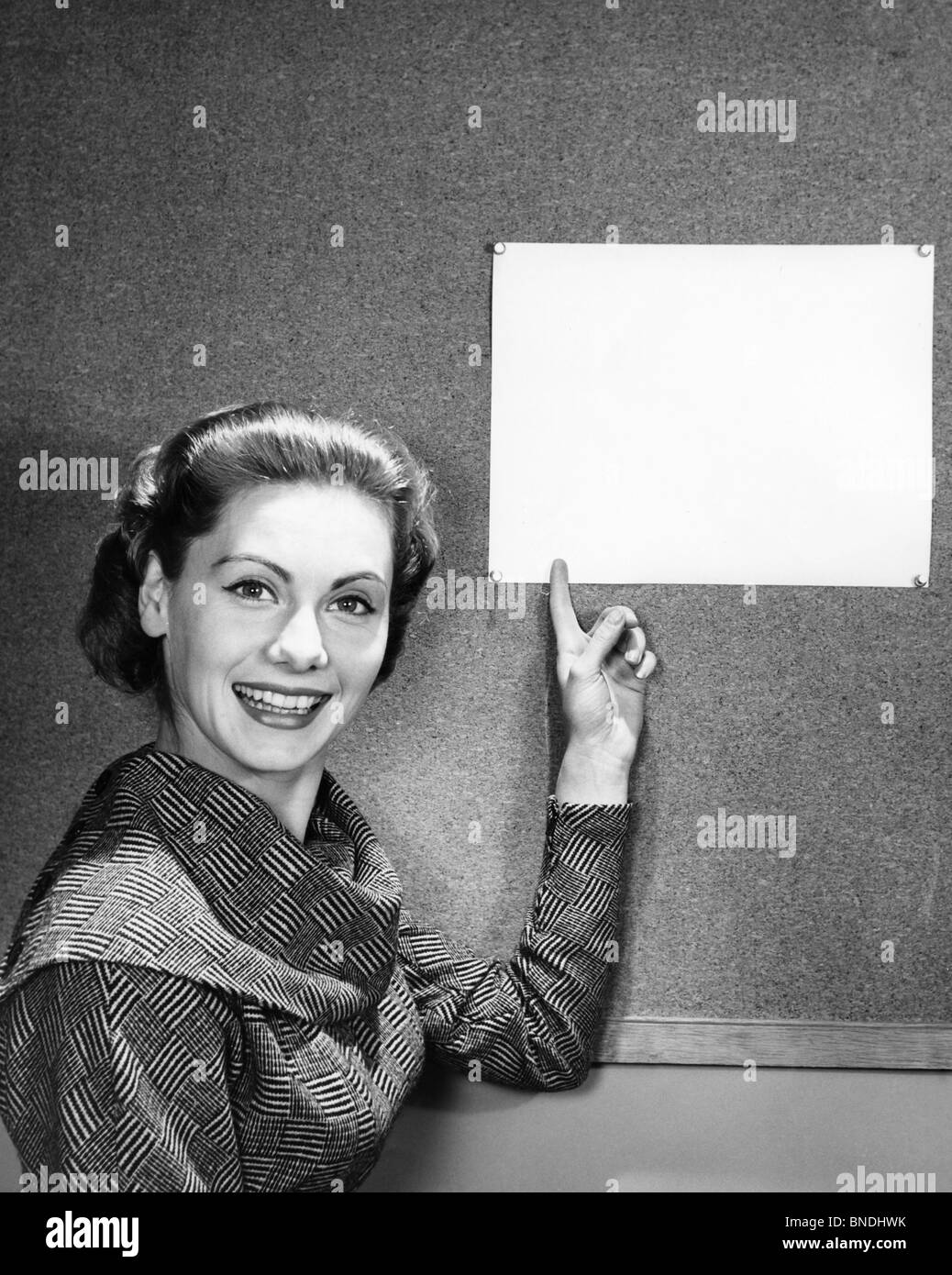 Portrait of a young woman pointing to a blank placard Stock Photo
