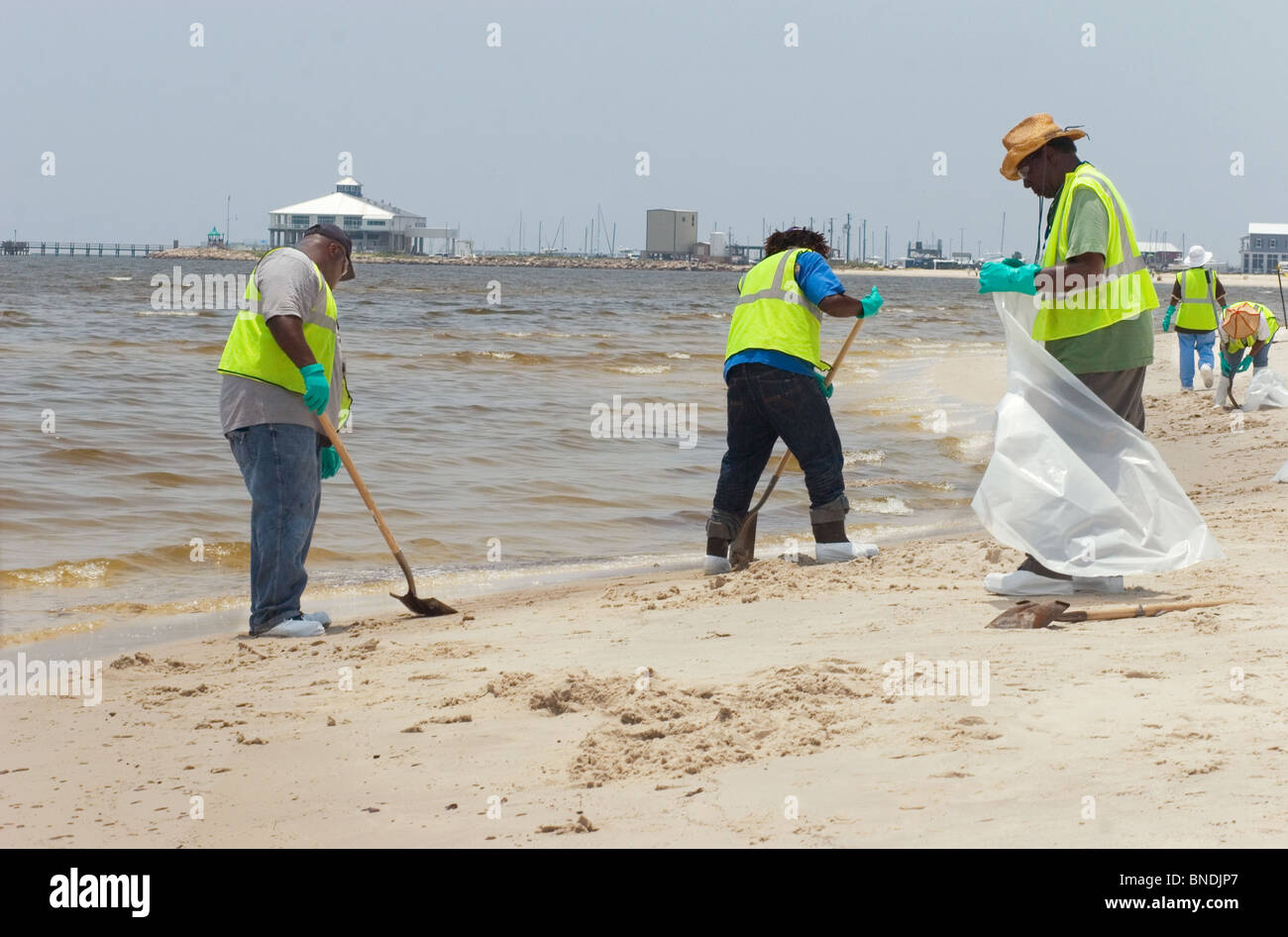 Sanitation workers cleaning up the beaches in Pass Christian, Mississippi during the BP oil spill.  July, 2010. Stock Photo