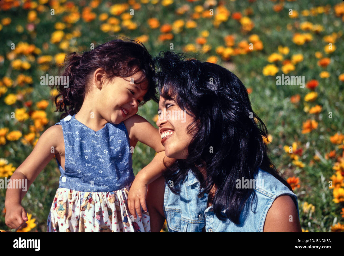 Happy mother and daughter 4  years old daughter smiling field flowers.multi ethnic inter racially diverse  Filipina Stock Photo