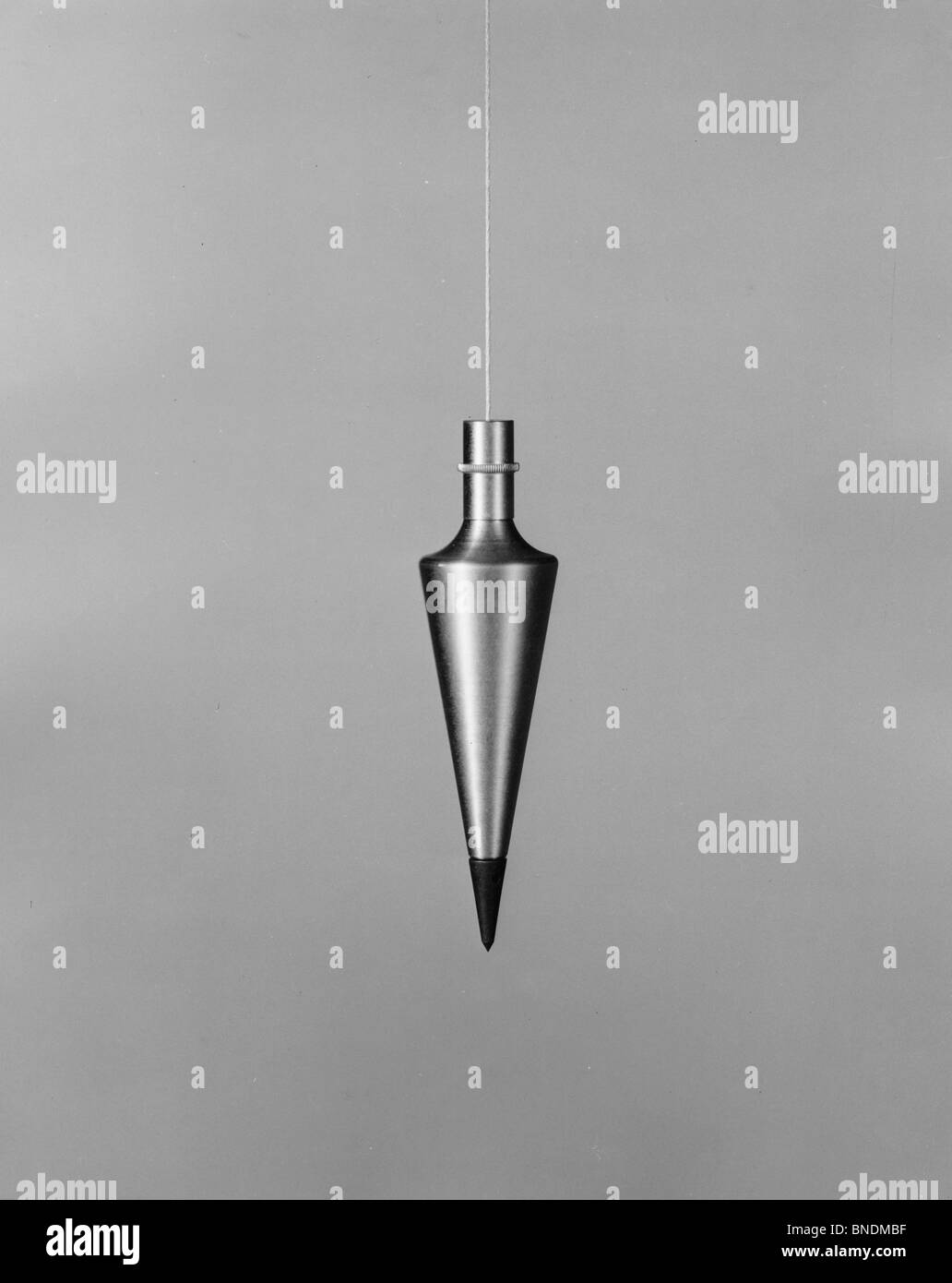 Plumb weight hanging on a string Stock Photo