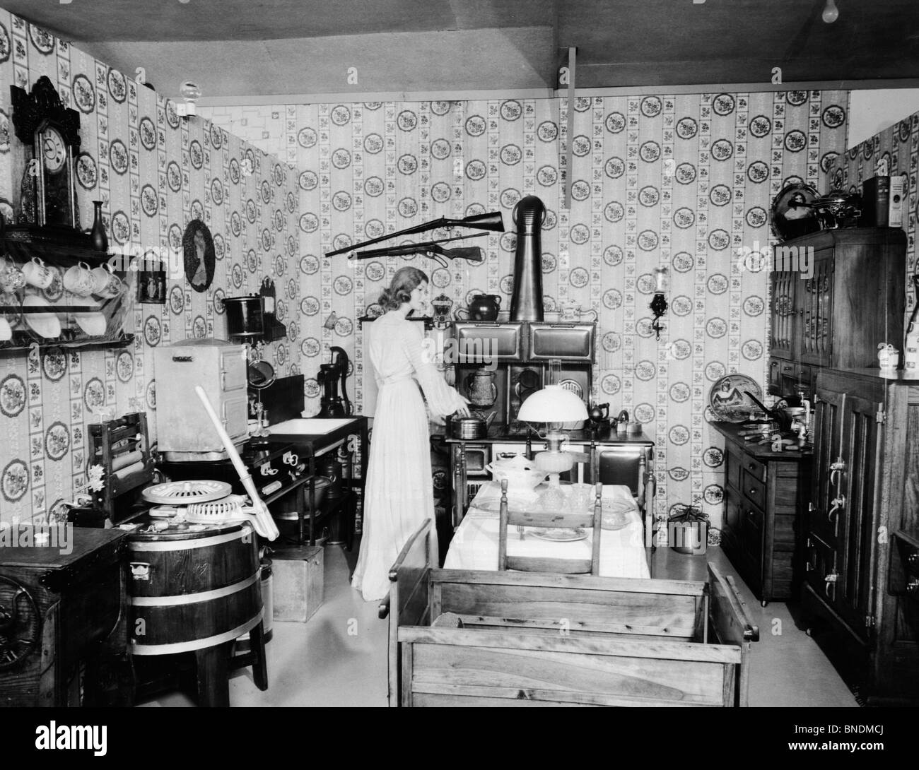 Rear view of a young woman preparing food in a kitchen, Pioneer Village, Minden, Nebraska, USA Stock Photo