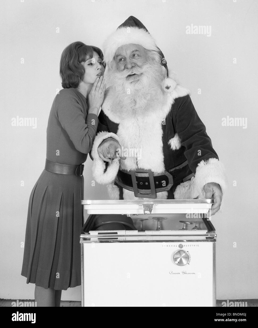 Woman whispering to Santa Claus Stock Photo