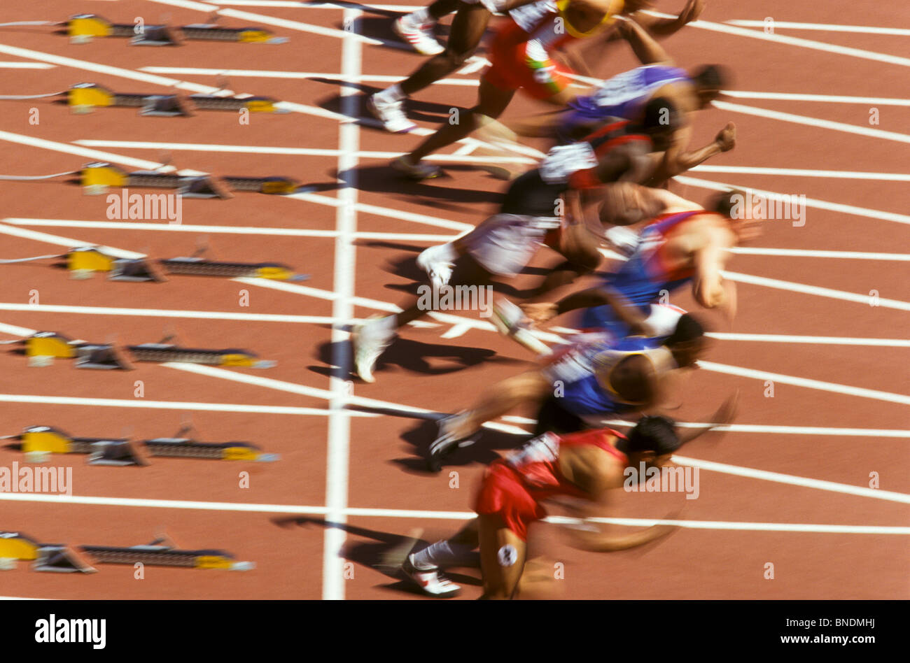 Blurred action of male runners starting a 100 meter sprint race. Stock Photo