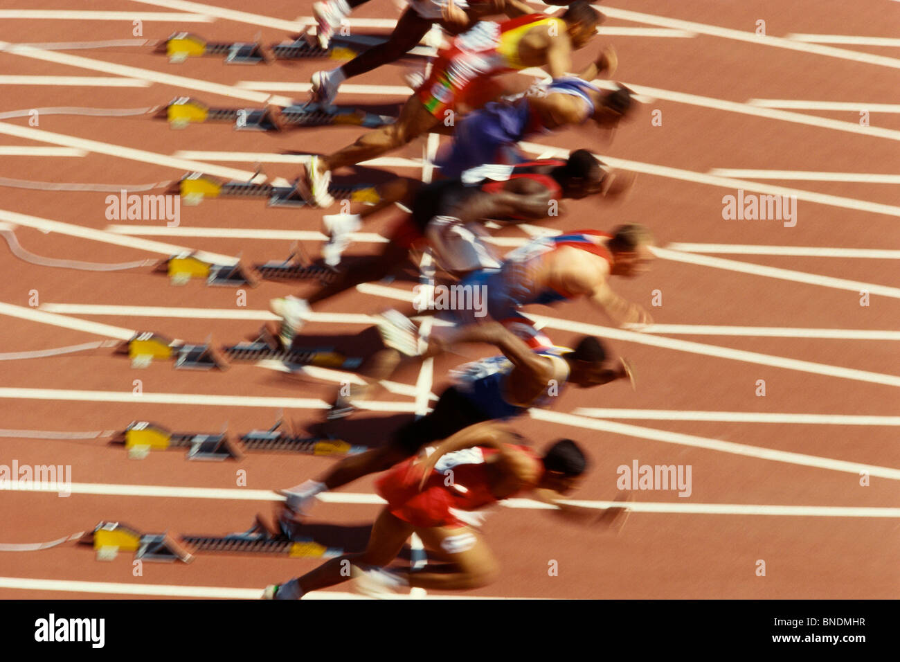 Blurred action of male runners starting a 100 meter sprint race. Stock Photo