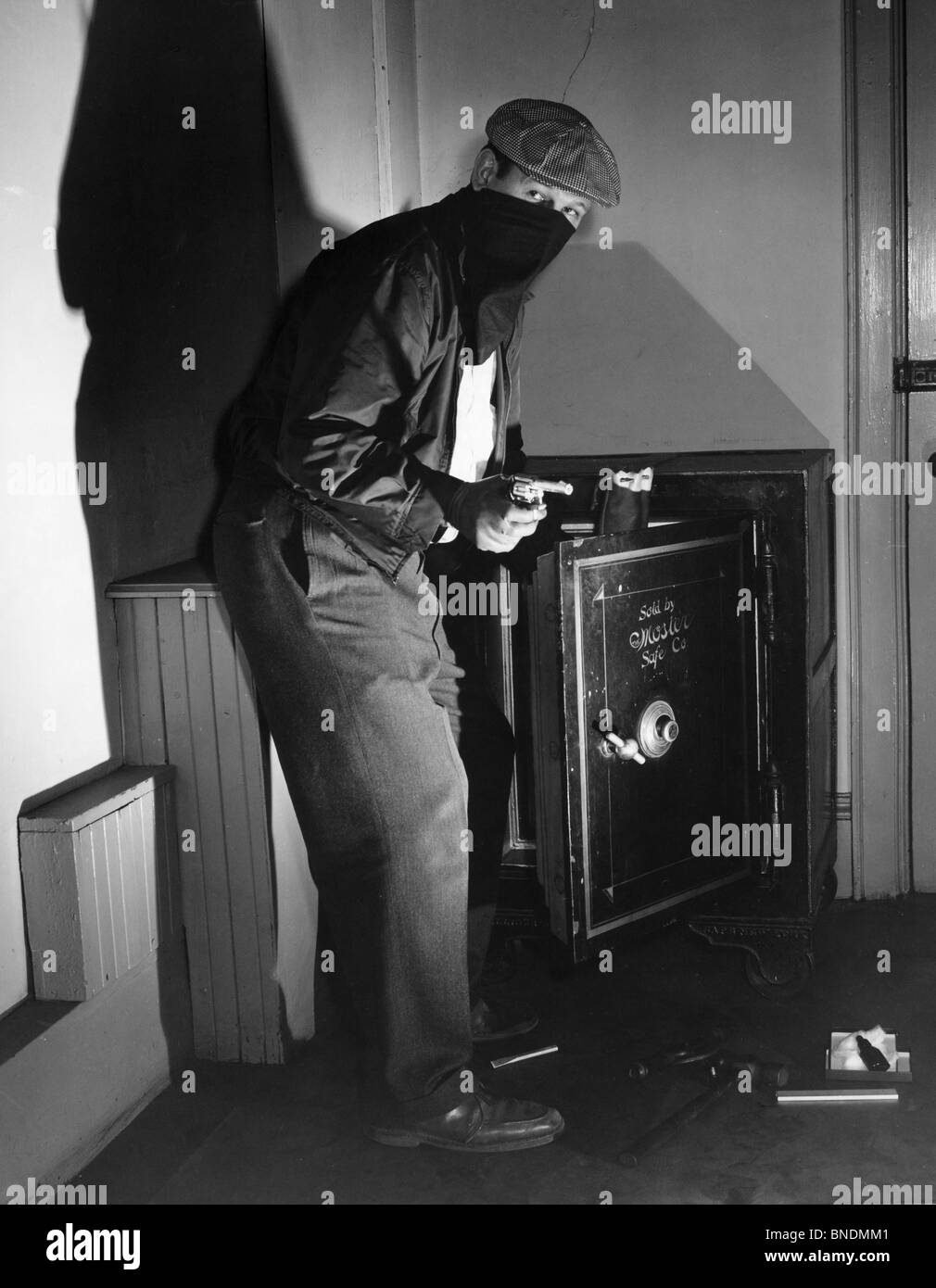 Portrait of a thief standing near an open safe Stock Photo