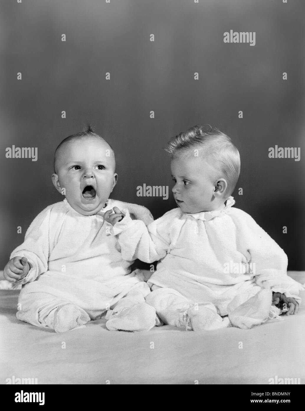 Two babies sitting together Stock Photo