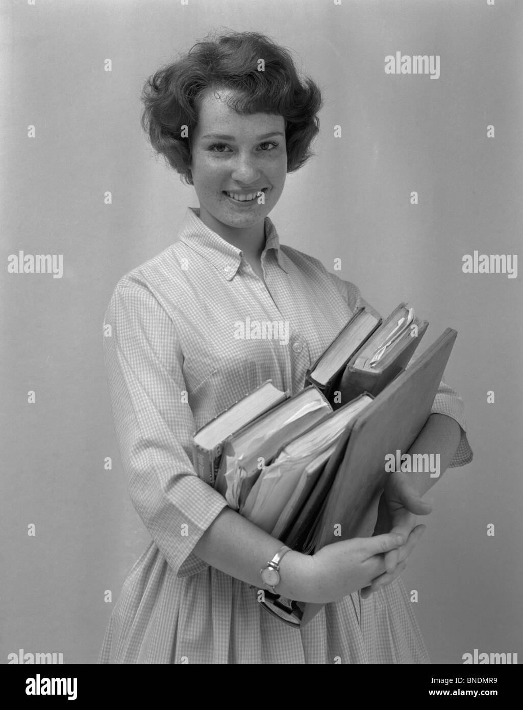 Portrait of a smiling teenage girl holding books Stock Photo - Alamy