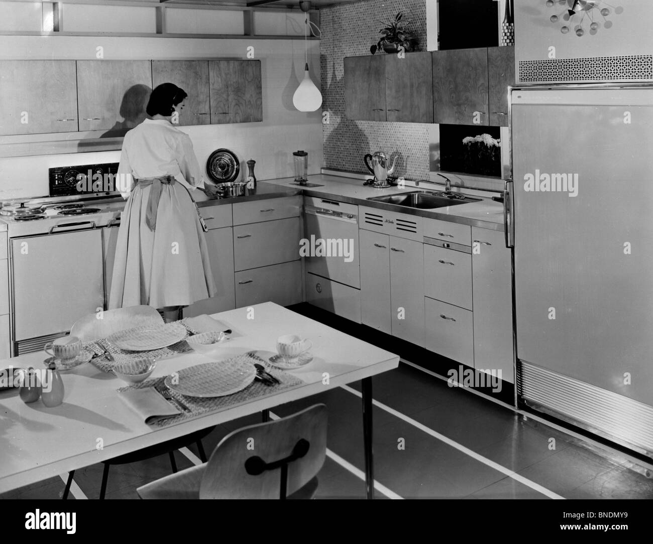 Rear view of a young woman preparing food in a kitchen Stock Photo