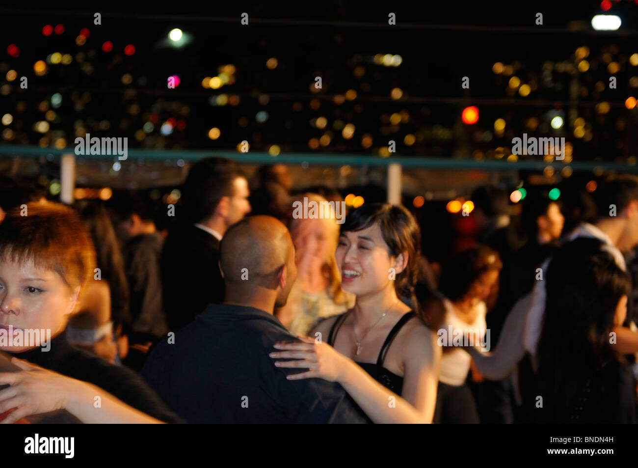 Young people on a Latin dance club boat cruise with Toronto skyline lights at night Stock Photo