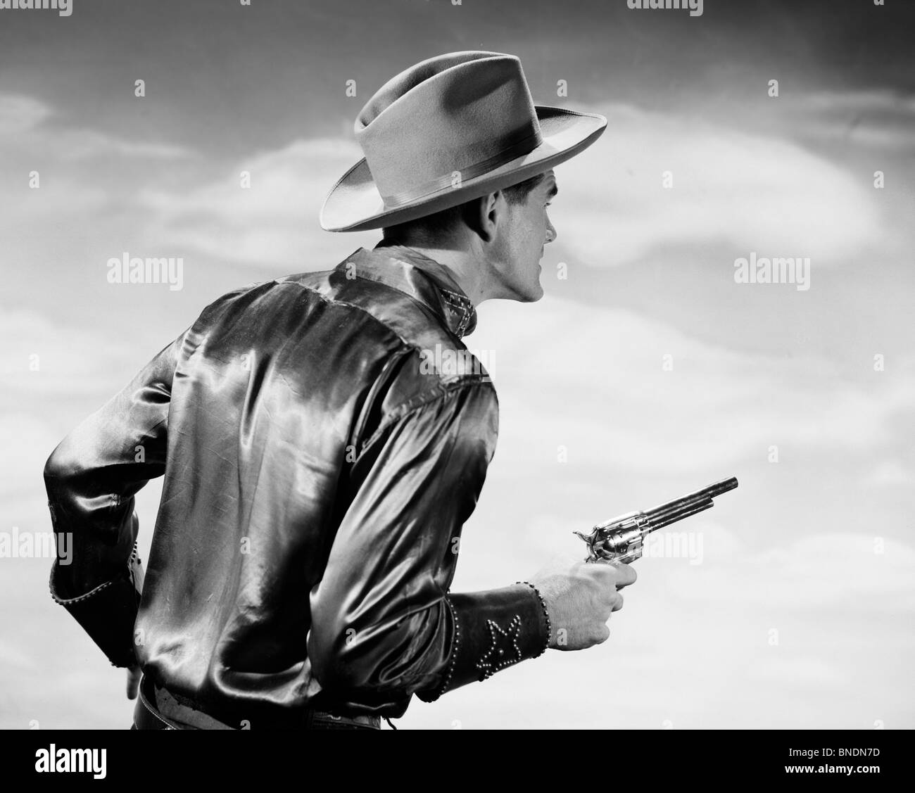 Rear view of a cowboy holding a pistol Stock Photo Alamy