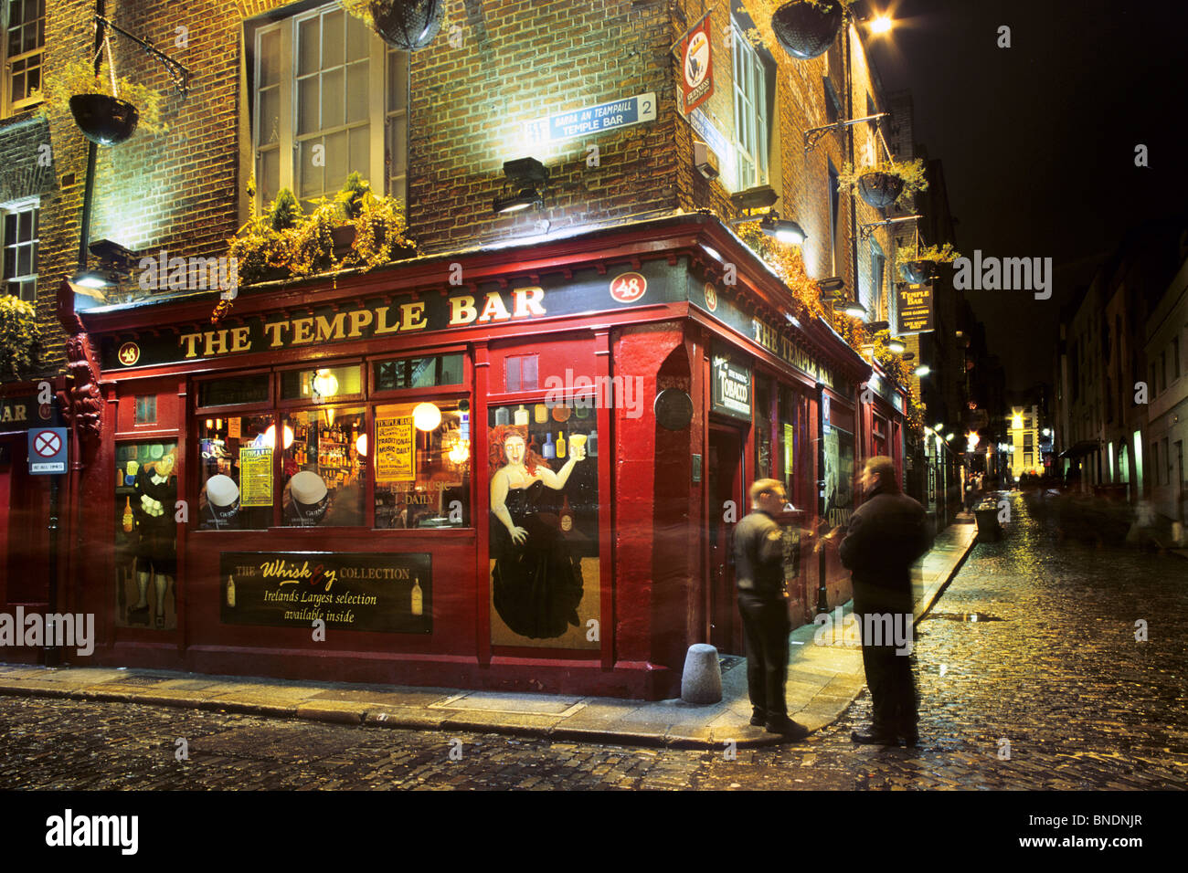 People Standing Outside An Irish Pub Called The Temple Bar At Night People Standing Outside An Irish Pub Called The Temple Bar At Night