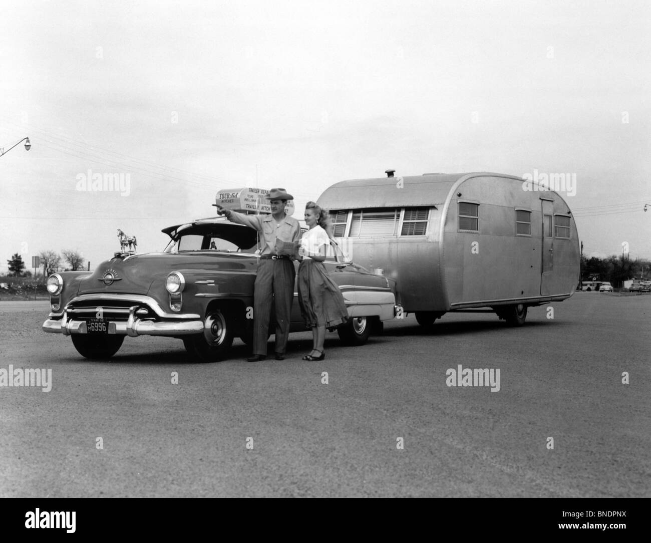 Mid adult couple standing with a car, 1952 Stock Photo