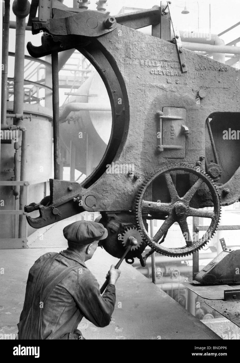 Rear view of a man operating machinery in a factory, 1939 Stock Photo ...