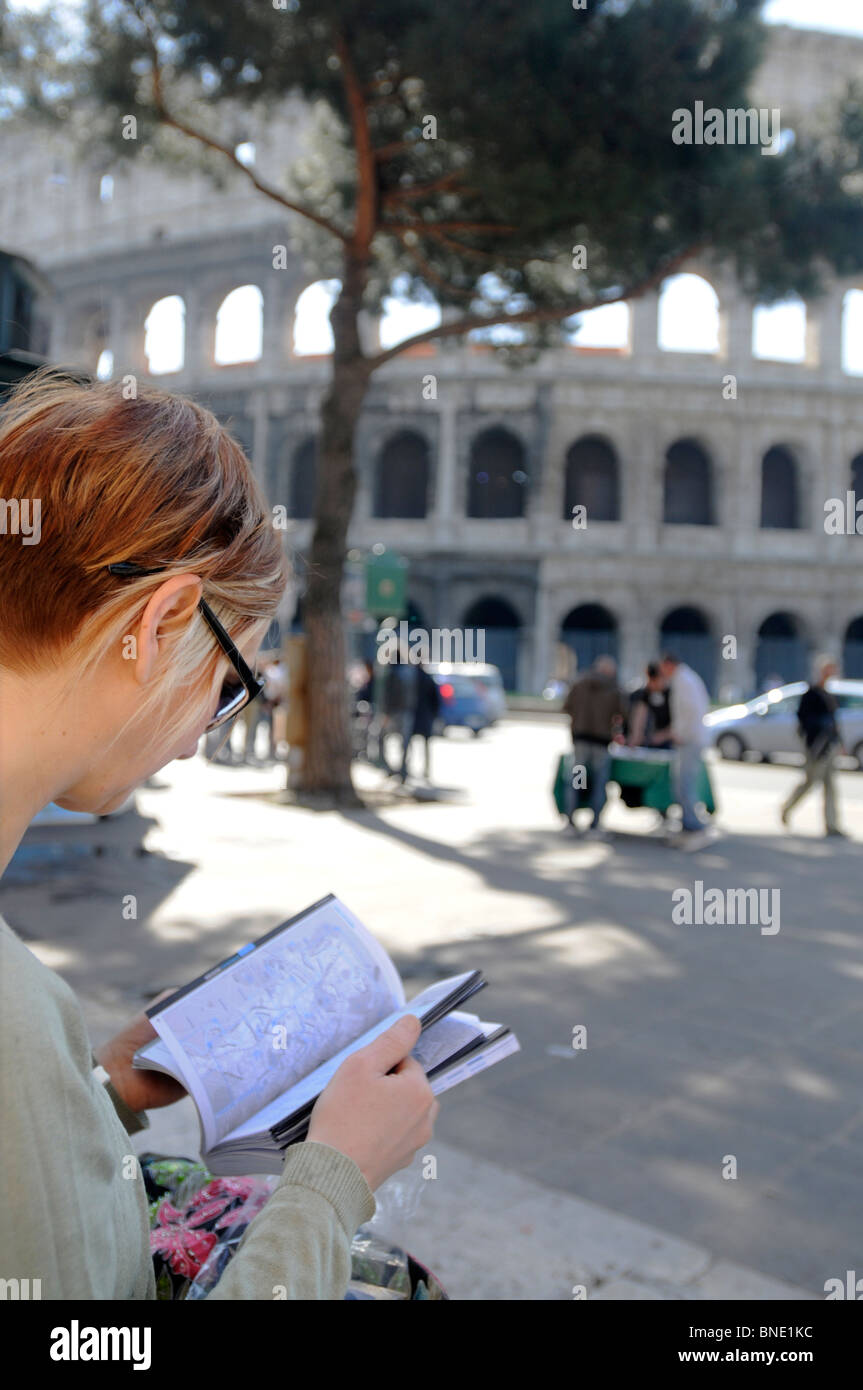 Female tourist with guidebook, Colosseum, Rome, Italy Stock Photo