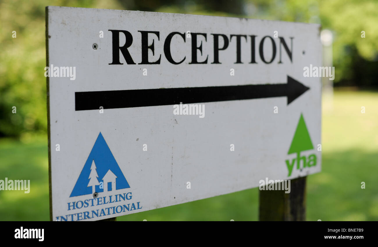 YHA reception sign with an arrow and logos on it outside in the youth hostel grounds Stock Photo