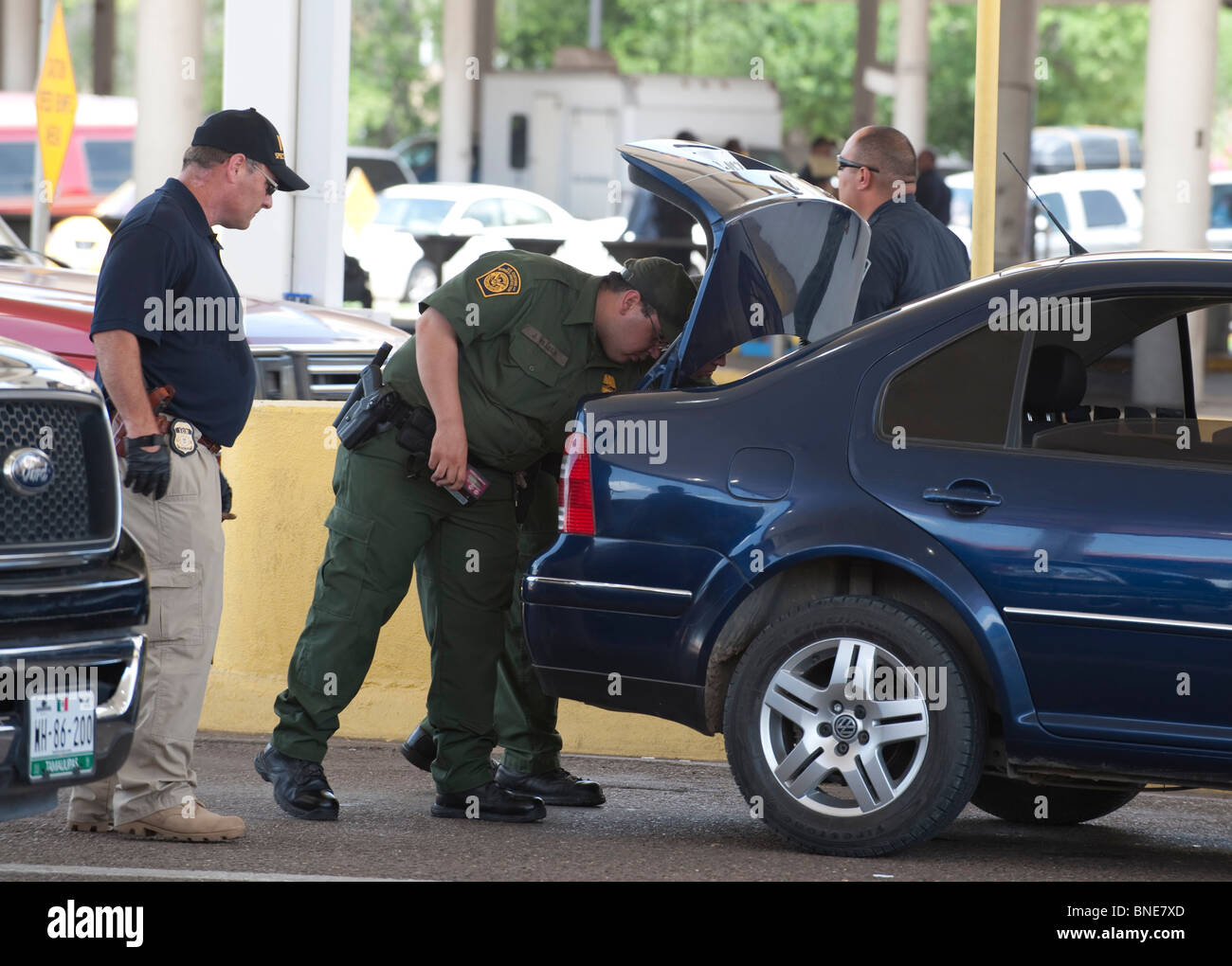 U.S. federal agents from ICE and Border Patrol inspect vehicles headed
