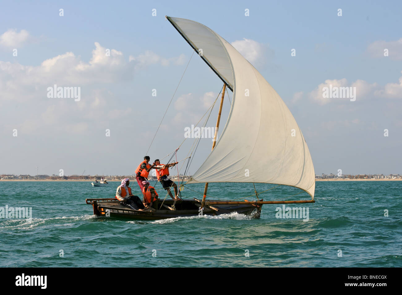 Young sailors in a traditional racing dhow in the Arabian (Persian) Gulf, off Dubai, UAE. Stock Photo