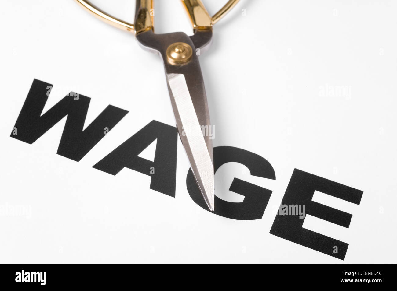 text of wage and scissors, concept of salary cut Stock Photo