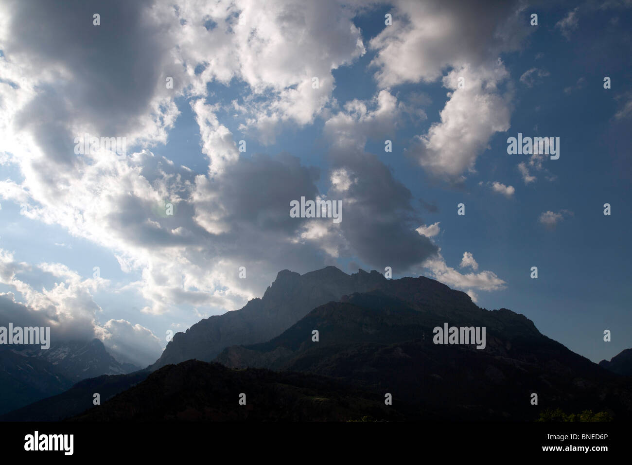 Alpine mountain with the sunlight breaking through the heavens Stock ...
