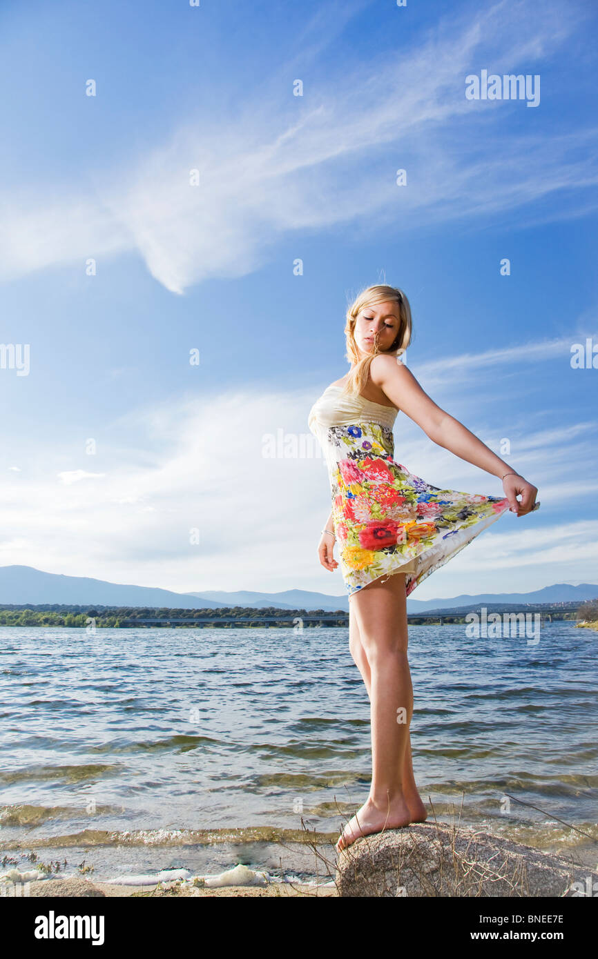 young blonde beautiful girl posing near a lake Stock Photo - Alamy