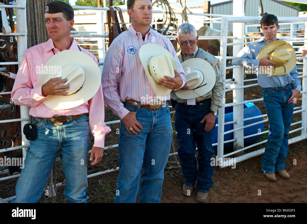 Four rodeos member of PRCA singing their National Anthem in horse stable in Smalltown, Bridgetown Texas, USA Stock Photo