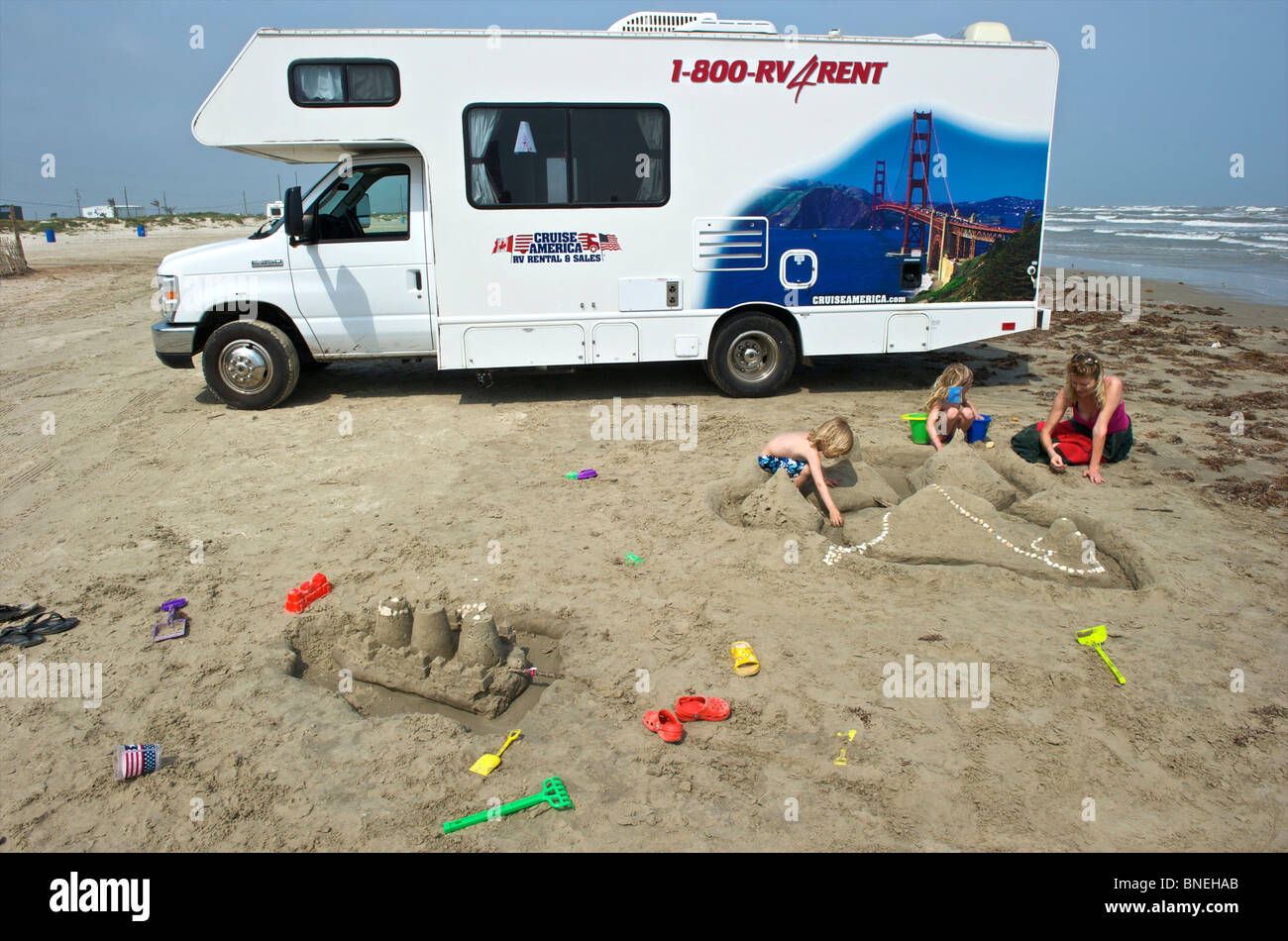 Family with rental camper campervan RV on beach in Galveston, Texas