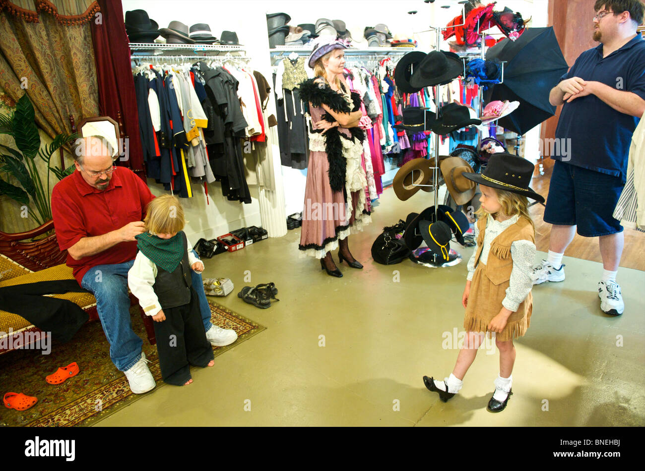 Tourist family getting ready in western style at Wildwest clothing for photo shoot in Galveston, USA Stock Photo