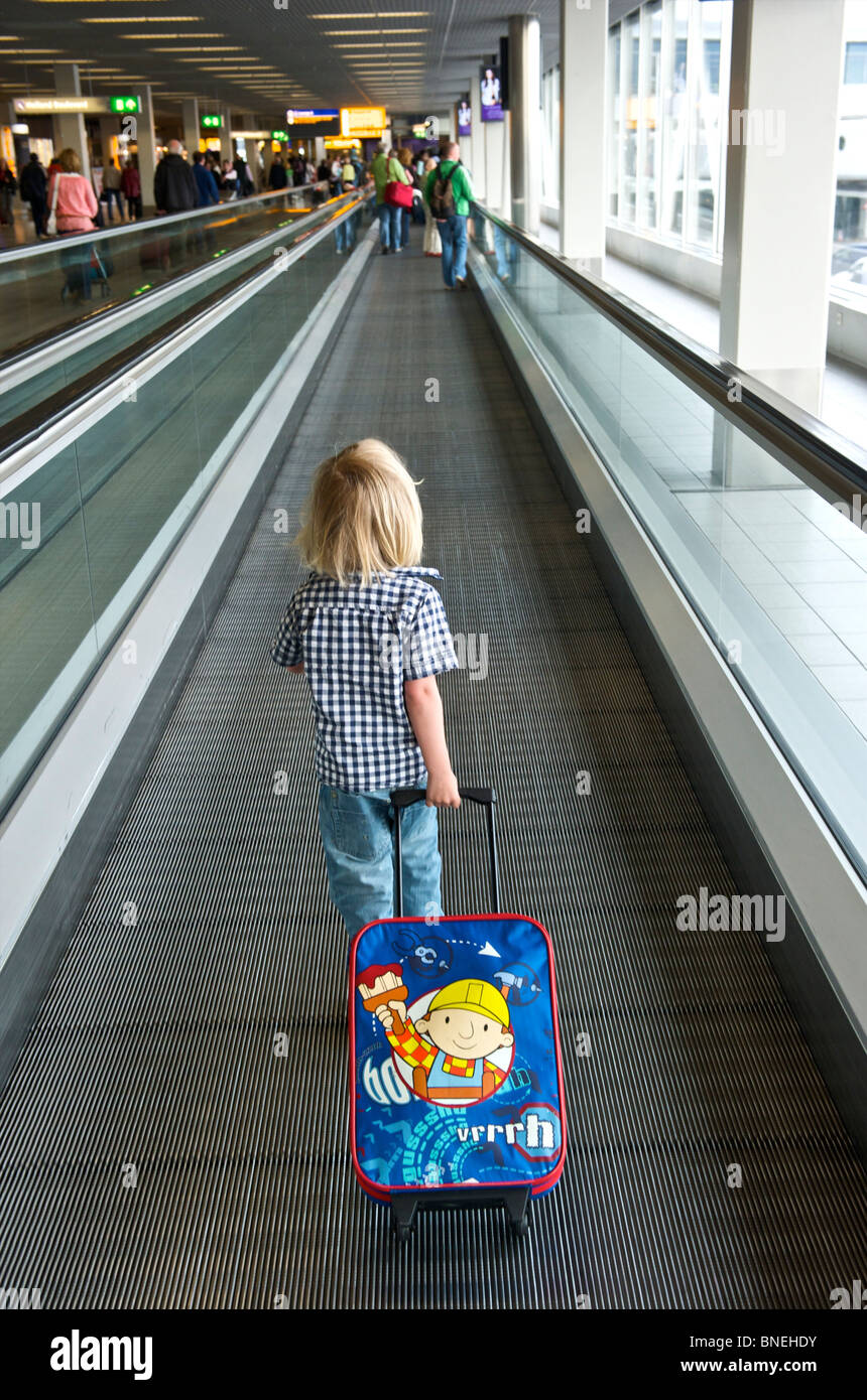 Three year old boy on his way to departure hall at Schiphol Airport in Netherlands, Europe Stock Photo