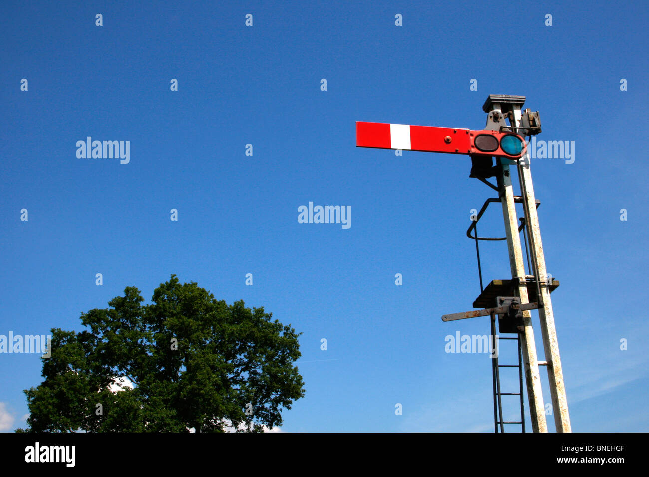 A railway semaphore signal and a tree. Stock Photo