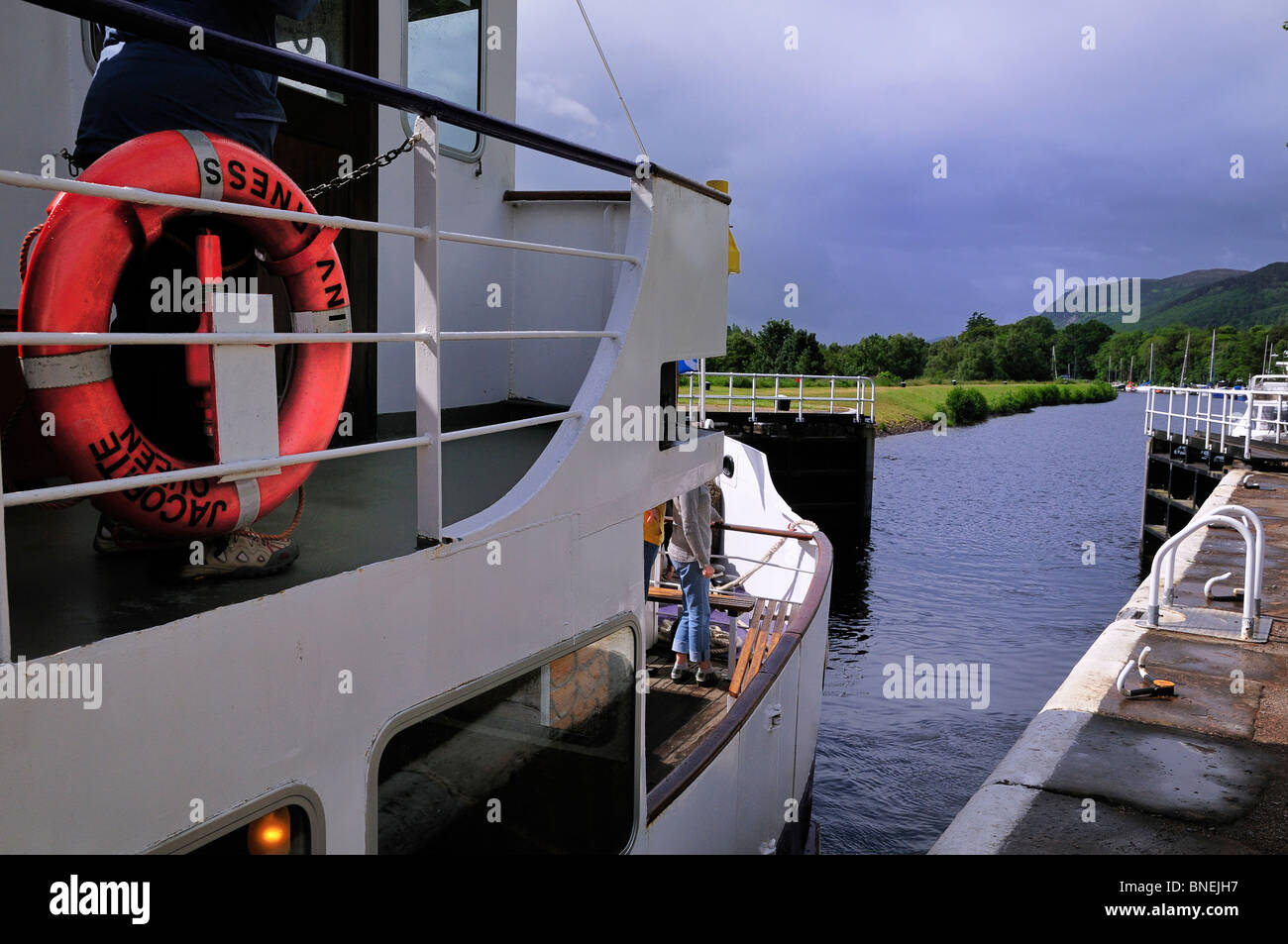The gates swing open allowing the Jacobite Queen out of Inverness to leave a lock chamber on the Caledonian Canal Stock Photo
