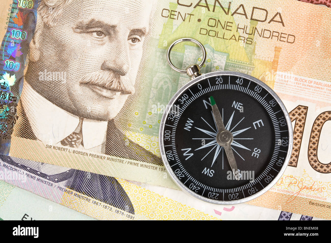 Compass and canadian dollar close up shot Stock Photo - Alamy