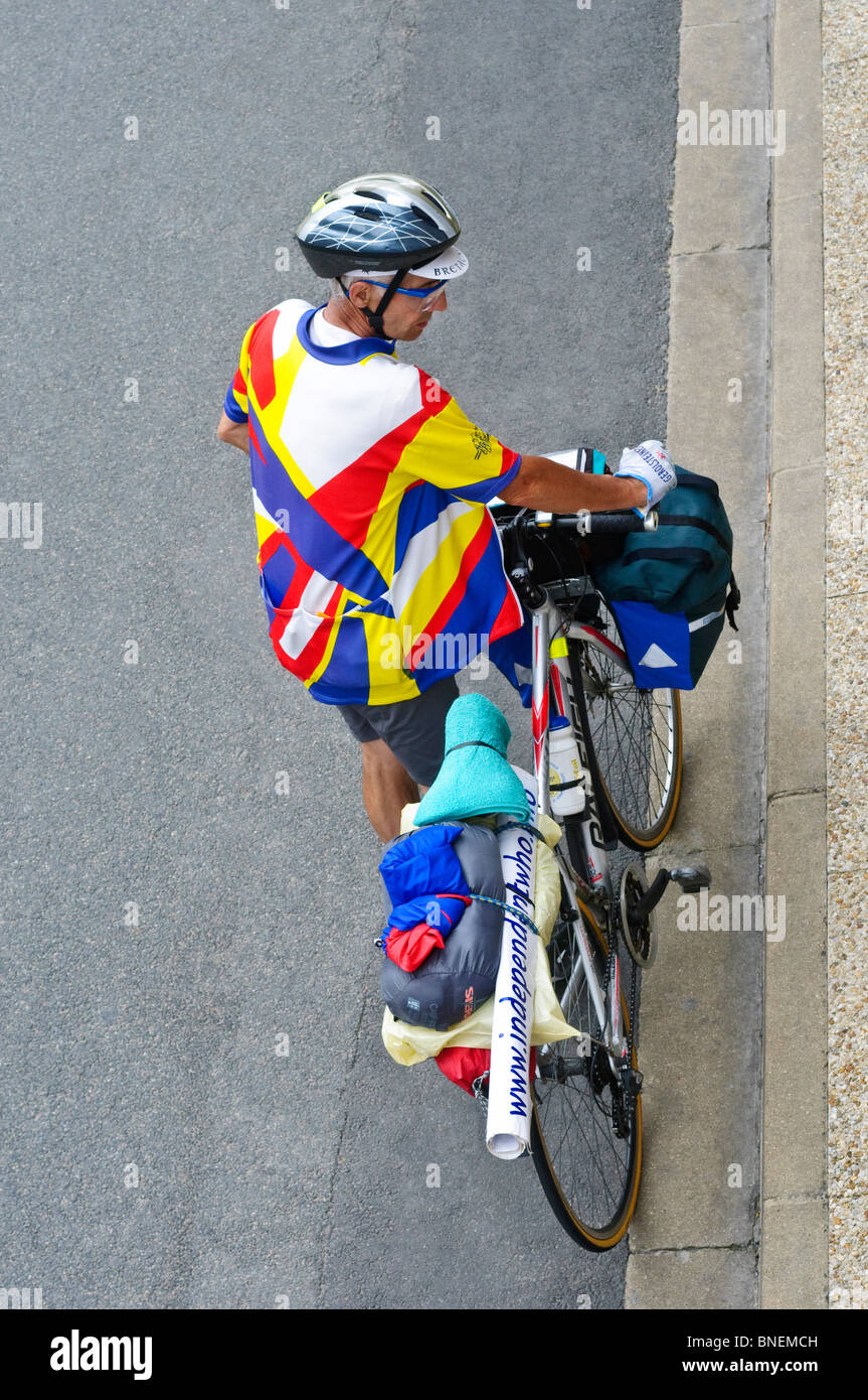 Touring cyclist waiting at kerb - France. Stock Photo