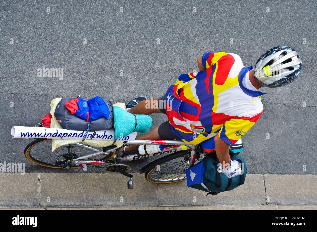 Touring cyclist waiting at kerb - France. Stock Photo