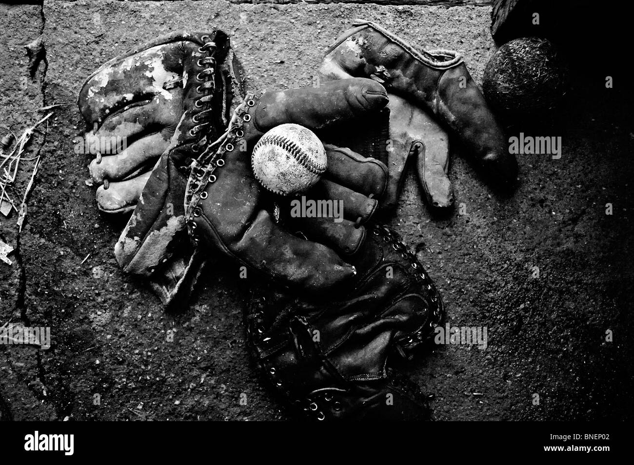 Weathered, worn antique 1950s era baseball gloves collect dust in an old farm house on the mid American plains of Oklahoma Stock Photo