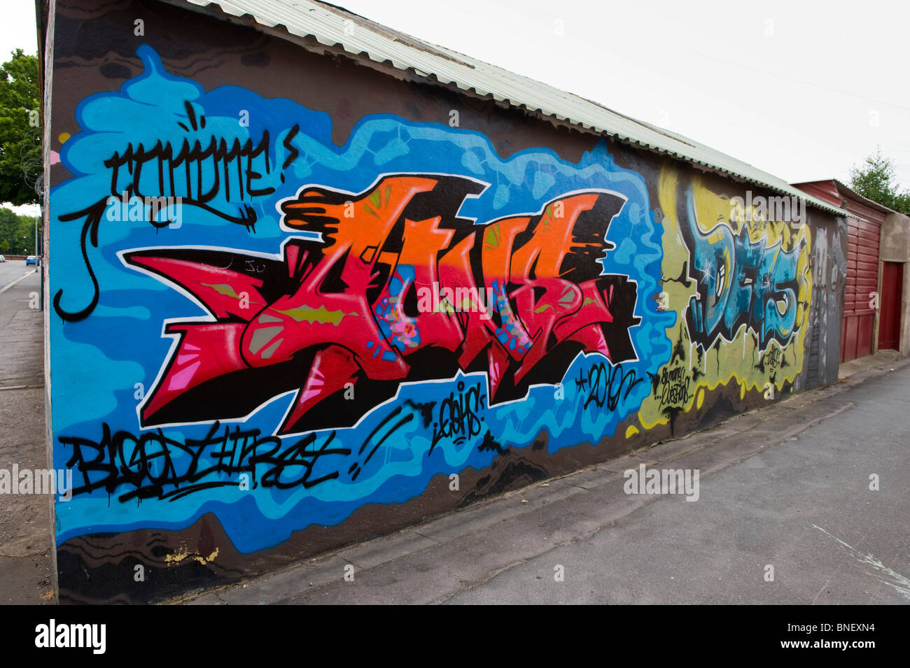 Urban graffiti art on wall of garage in back lane of Cardiff South