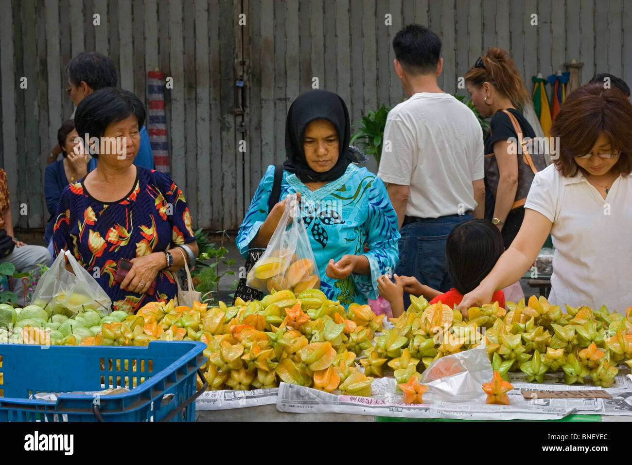 Women buying starfruit at a fruit stall in Kota Kinabalu, Sabah, Malaysia Stock Photo