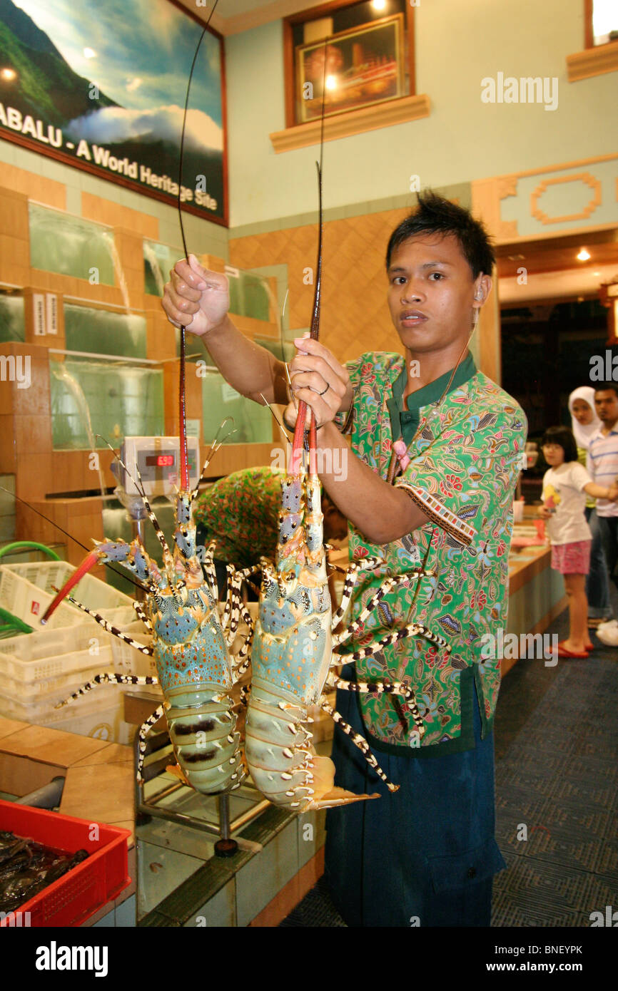 Man holding two lobsters in a seafood restaurant, Kota Kinabalu, Sabah, Malaysia Stock Photo